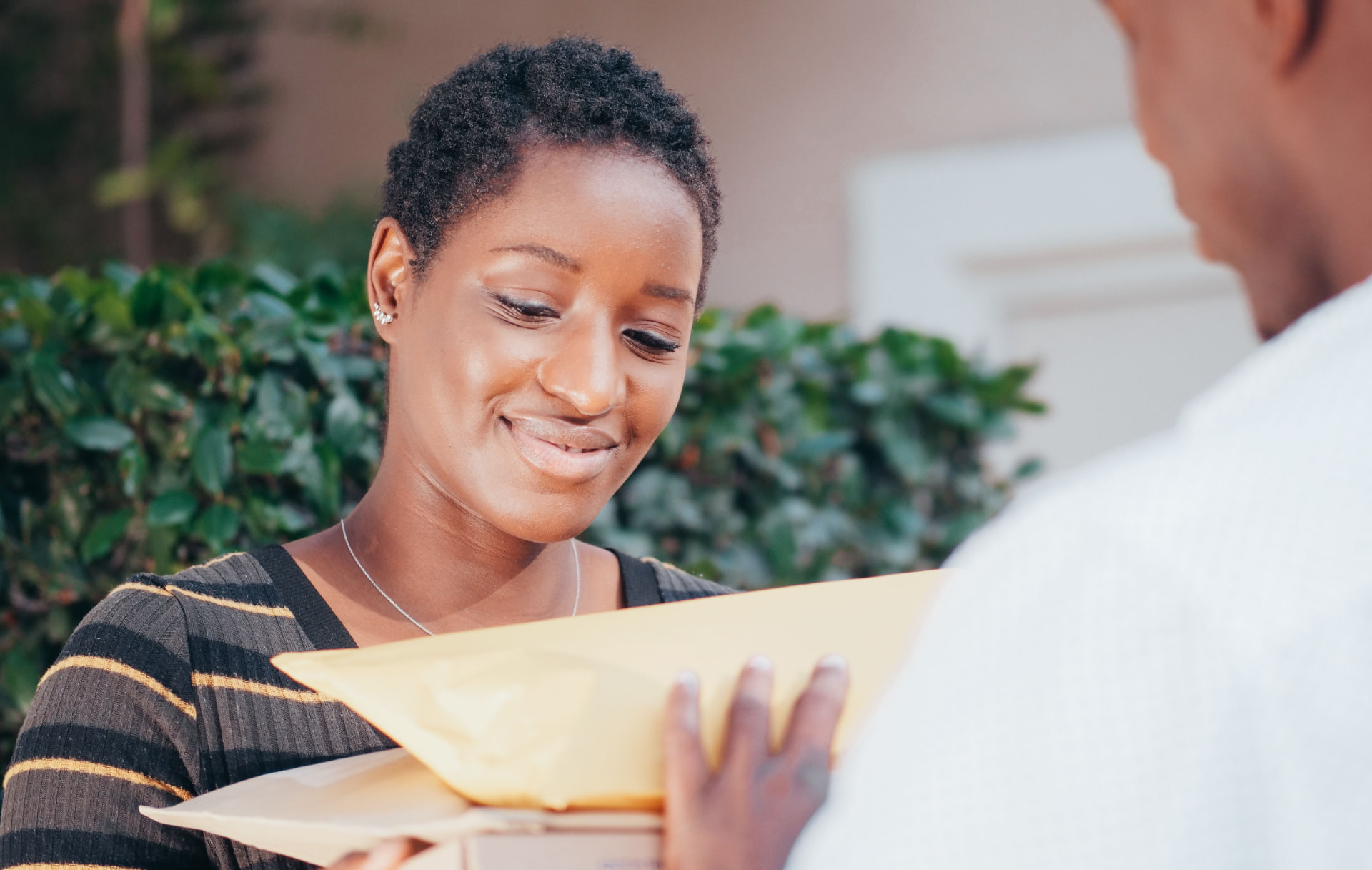 Two people exchanging a small parcel wrapped in brown paper and string
