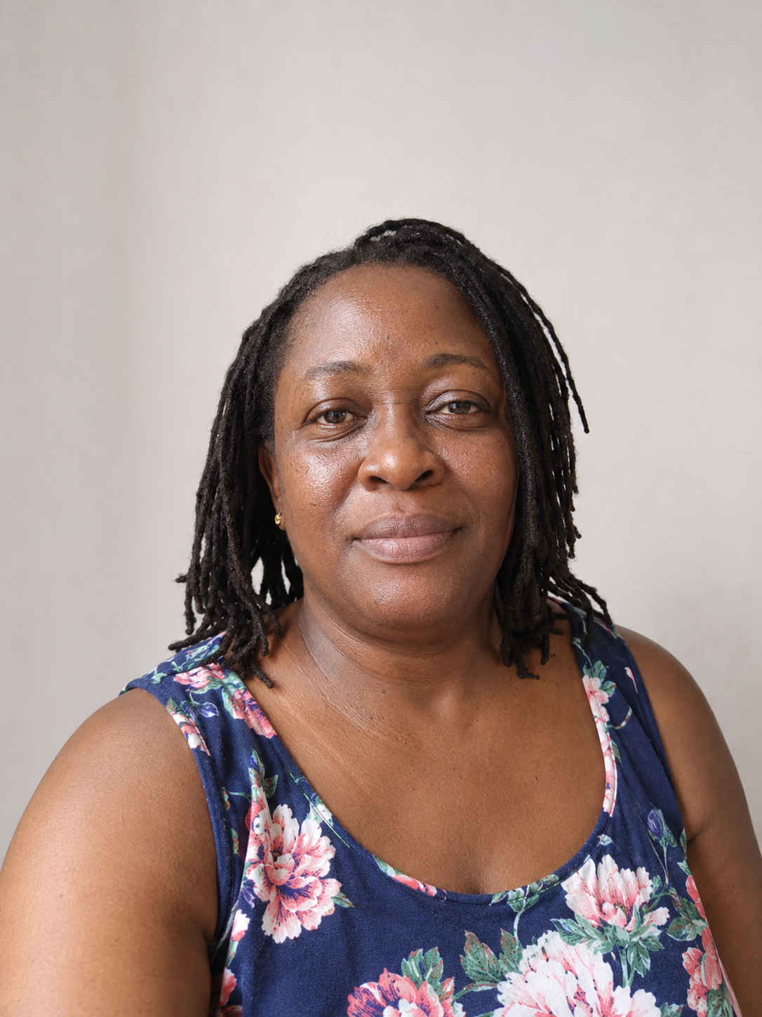 Ama, a sender, portrait against a warm neutral wall
